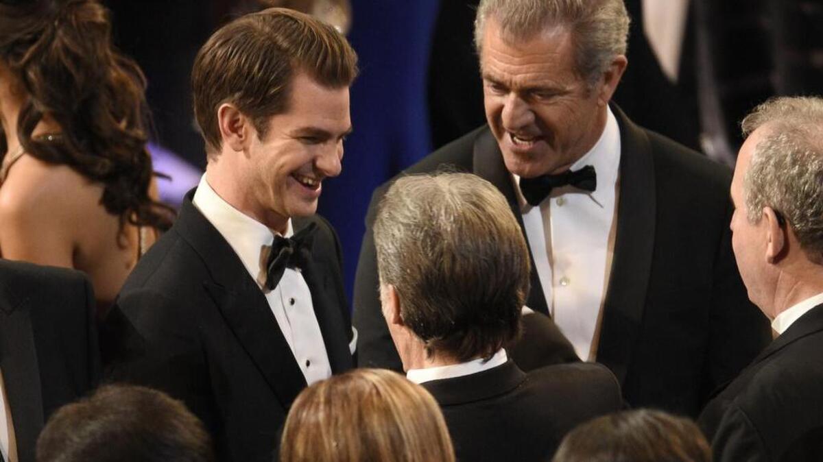 Andrew Garfield, left, and Mel Gibson talk with people at the Oscars on Sunday, Feb. 26, 2017, at the Dolby Theatre in Los Angeles.