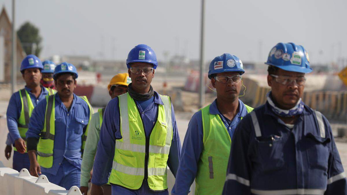 Workers walk to the Lusail Stadium, one of the 2022 World Cup stadiums, in Lusail, Qatar, Friday, Dec. 20, 2019. Between 400 and 500 World Cup workers died, according to a Qatari official. (AP Photo/Hassan Ammar)