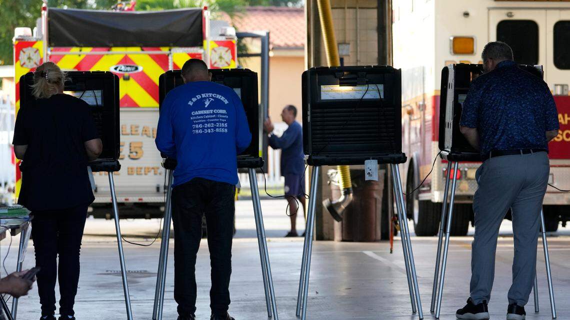 People vote in the midterm election at a fire station, Tuesday, Nov. 8, 2022, in Hialeah, Fla. Experts and officials urge patience in waiting for the election results.