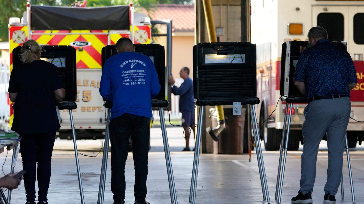 People vote in the midterm election at a fire station, Tuesday, Nov. 8, 2022, in Hialeah, Fla. Experts and officials urge patience in waiting for the election results.