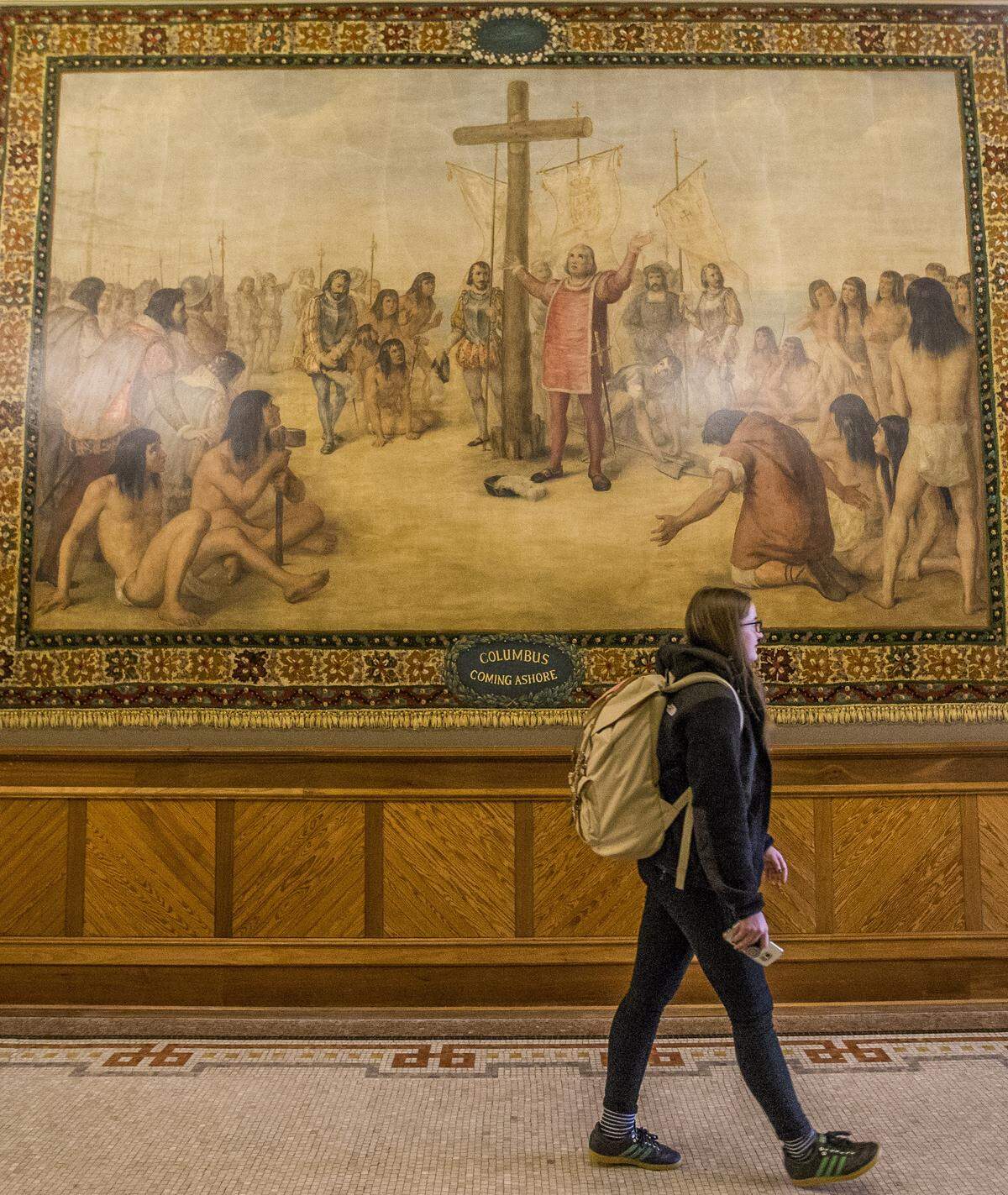 Kristin Fabian walks by a mural of Christopher Columbus at Notre Dame in November 2017.