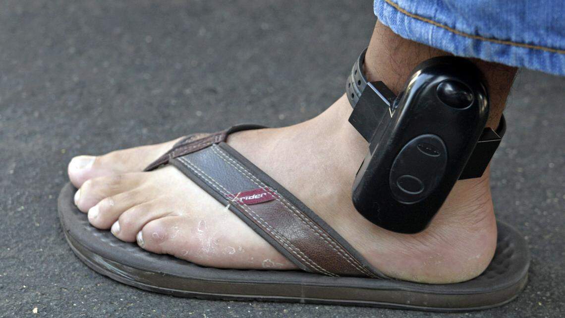 A parolee wears an ankle bracelet while being arrested by a parole agent outside his home in Los Angeles. A Tampa area company is offering Florida parents ankle monitors for their teens without court orders.
