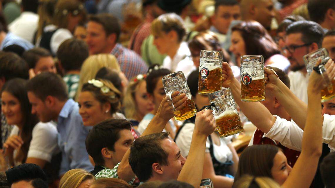 People cheer during the opening of the Oktoberfest beer festival in Munich,  Germany — holding beers that are a world away from the porridge-like brews the Natufians drank 13,000 years ago in what is today Israel, according to researchers.