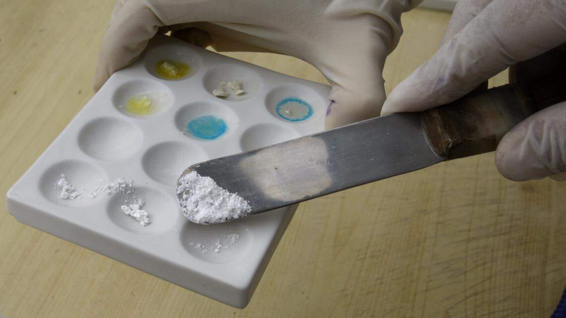 A Peruvian police officer tests cocaine during a drug burning operation at a police base in Lima.