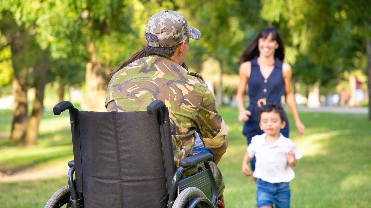 Family of a retired, disabled, military father running to hug him. A veteran of war or returning home concept.