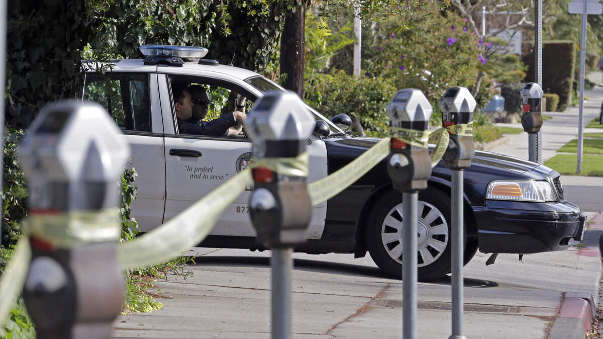 Officers in a patrol car keep watch in front of the West Los Angeles police station.