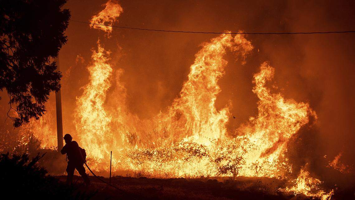 A firefighter passes flames from a backfire while battling the Delta Fire in California’s Shasta-Trinity National Forest in September.