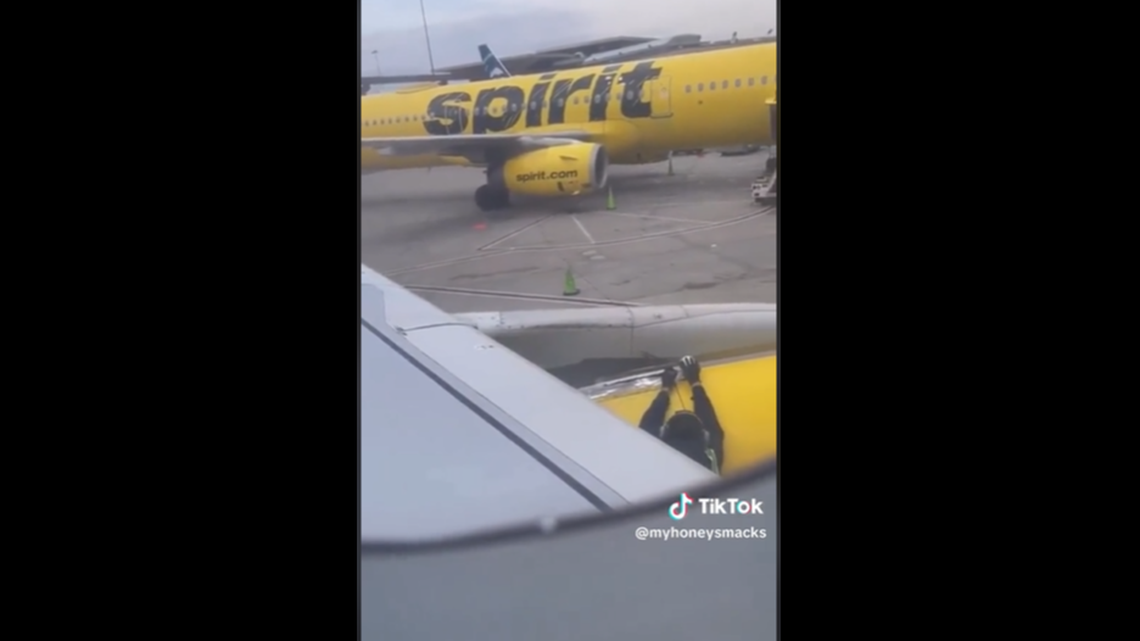 The Spirit employee was filmed rolling tape onto the wing as passengers took their seats.
