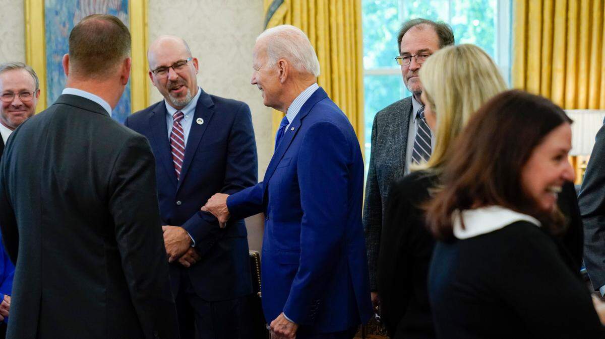 President Joe Biden meets with people in the Oval Office of the White House, Thursday, Sept. 15, 2022, in Washington. Biden’s approval rating ticked up in September, according to the latest poll from The Associated Press-NORC Center for Public Affairs Research.