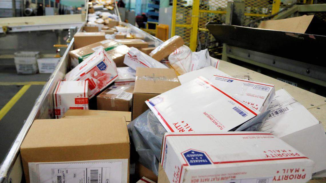 FILE- In this Dec. 14, 2017, file photo, packages travel on a conveyor belt for sorting at the main post office in Omaha, Neb. U.S. Attorney Damian Williams announced charges against nine individuals, including three postal workers, on Sept. 29, alleging that they stole $1.3 million. (AP Photo/Nati Harnik, File)