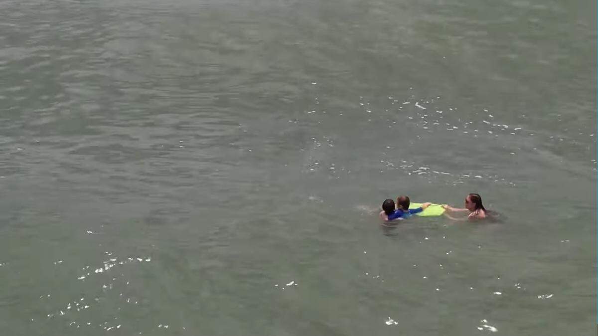 Drone footage shows a teenager from Ohio rescuing a mom and son from a riptide at Topsail Beach on the North Carolina coast over the July 4 holiday weekend.