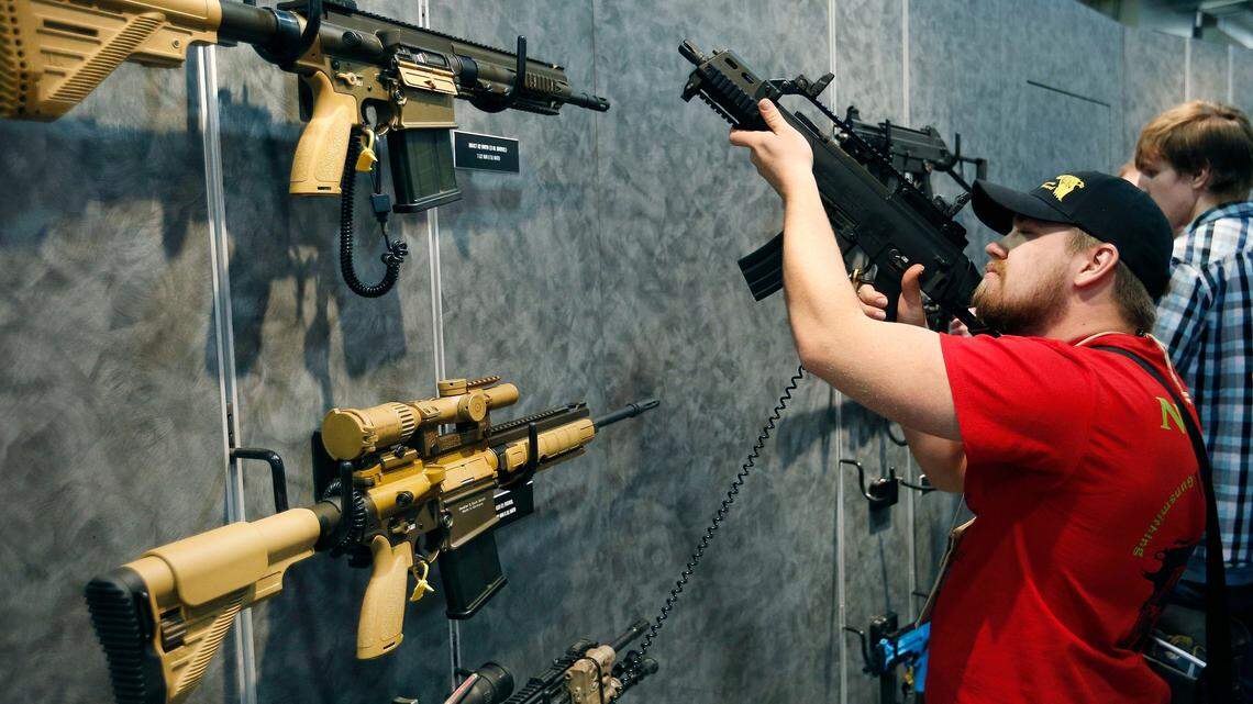 FILE - In this Jan. 19, 2016 file photo, customers look at a gun at the Heckler & Koch booth at the Shooting, Hunting and Outdoor Trade Show in Las Vegas. On Nov. 24, 2022, President Biden spoke in favor of an assault weapons ban. (AP Photo/John Locher, File)