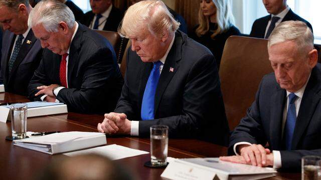 President Donald Trump prays during a cabinet meeting at the White House in 2017.