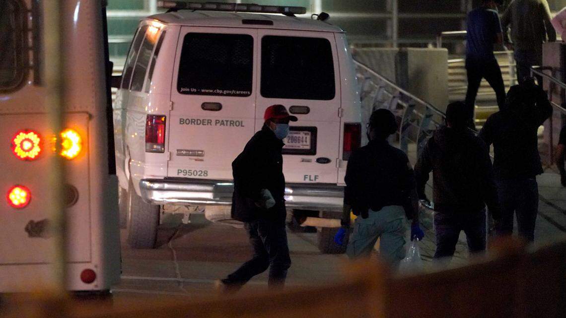 An official, second from left, looks on as migrants are deported to Mexico at the McAllen-Hidalgo International Bridge, Saturday, March 20, 2021, in Hidalgo, Texas. (AP Photo/Julio Cortez)