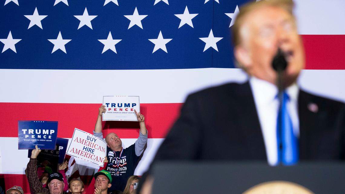 Audience members hold campaign posters as President Donald Trump speaks at a rally in Richmond, Kentucky, on Oct. 13.