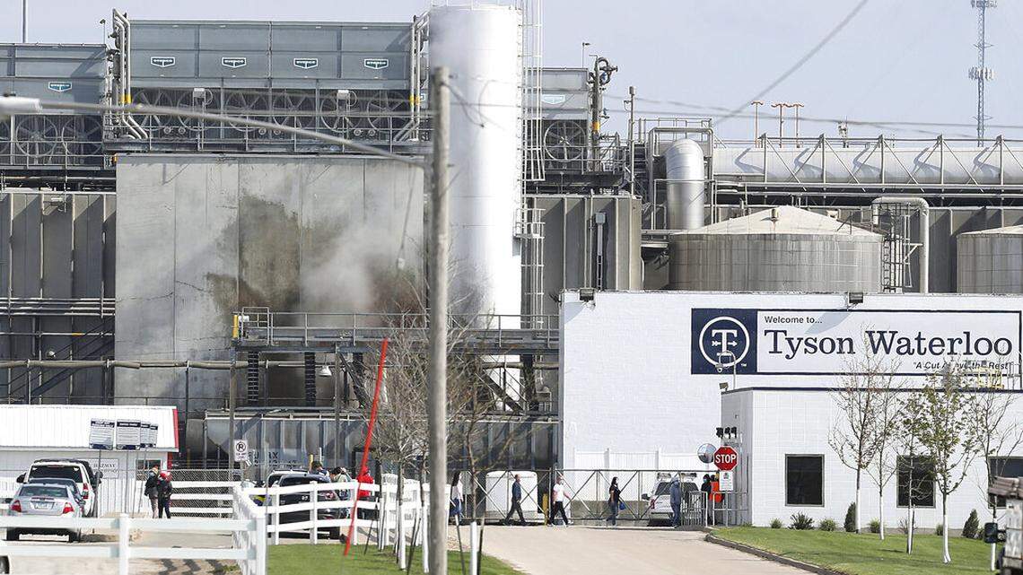 FILE - In this May 2020, file photo, Tyson’s Fresh Meat workers file in for a tour of safety measures put into place after the plant in Waterloo, Iowa, had to shut down due to a COVID-19 outbreak. The family of a Tyson Foods employee is alleging in a lawsuit that he died from COVID-19 after the meat processing giant failed to implement safety protocols to guard against the coronavirus at the Iowa plant where he worked. (Brandon Pollock/The Courier via AP, File)