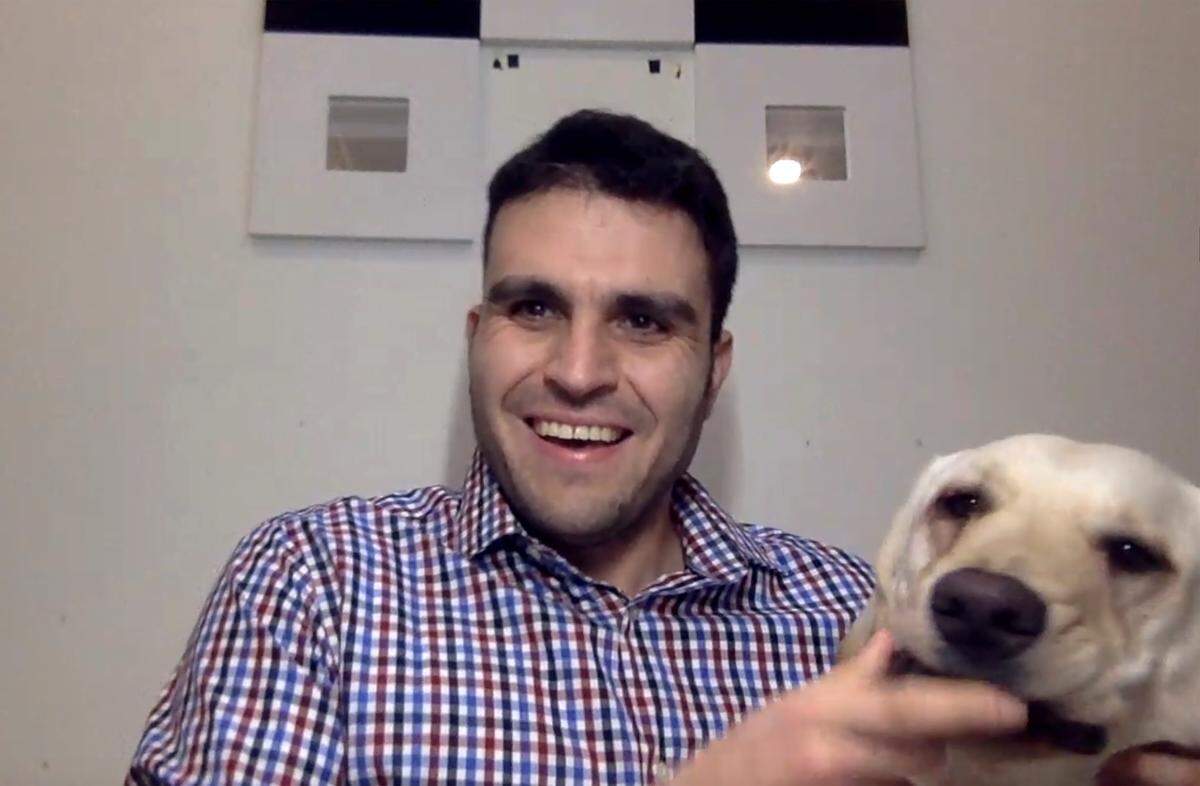 In this image made from video taken Monday, Jan. 27, 2020, U.S. citizen Doug Perez feeds his Labrador named Chubby during an interview in Wuhan, China. As hundreds of Americans prepare to evacuate Wuhan, the central Chinese city at the heart of a new virus outbreak that has killed over 100, Perez, a San Francisco native, is staying behind. He says he can’t leave behind his Chinese girlfriend or his dog and plans to ride out the epidemic. (AP Photo/Dake Kang)