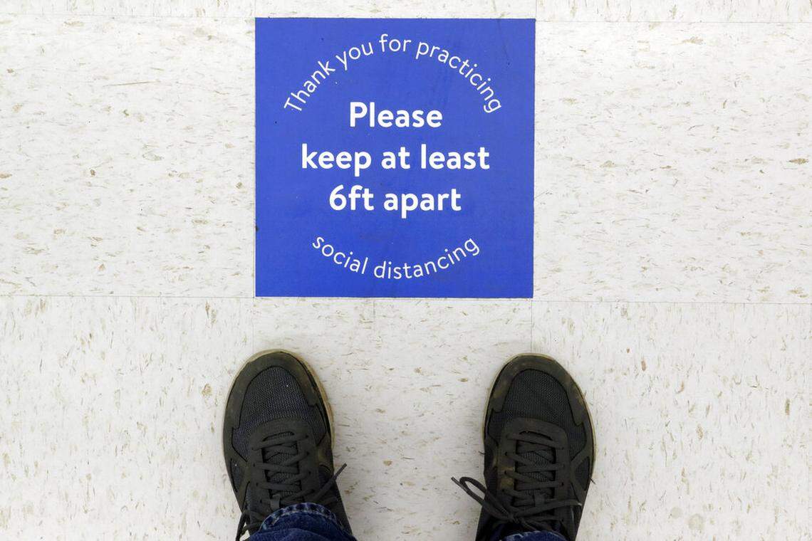 A sign reminds customers of social distancing in a store Friday, April 3, 2020, in Nashville, Tenn. Tennessee Gov. Bill Lee signed an executive order on Thursday that requires Tennesseans to stay at home except for essential activities amid the coronavirus pandemic. (AP Photo/Mark Humphrey)