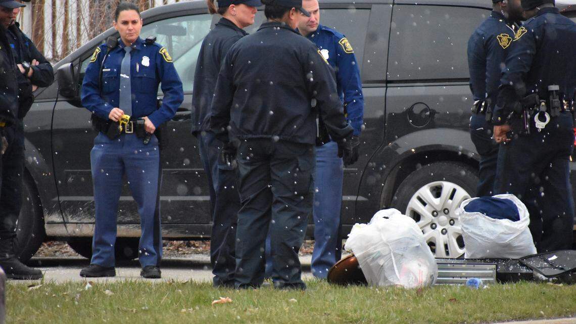 In this Wednesday, April 18, 2018 photo, officers investigate after two infant children were allegedly left in a suitcase along West Pierson Pierson Road in Flint, Mich. Both children were taken to a local hospital and listed in good condition. A 26-year-old woman was taken into custody in connection with the incident.  (Roberto Acosta/The Flint Journal-MLive.com via AP)