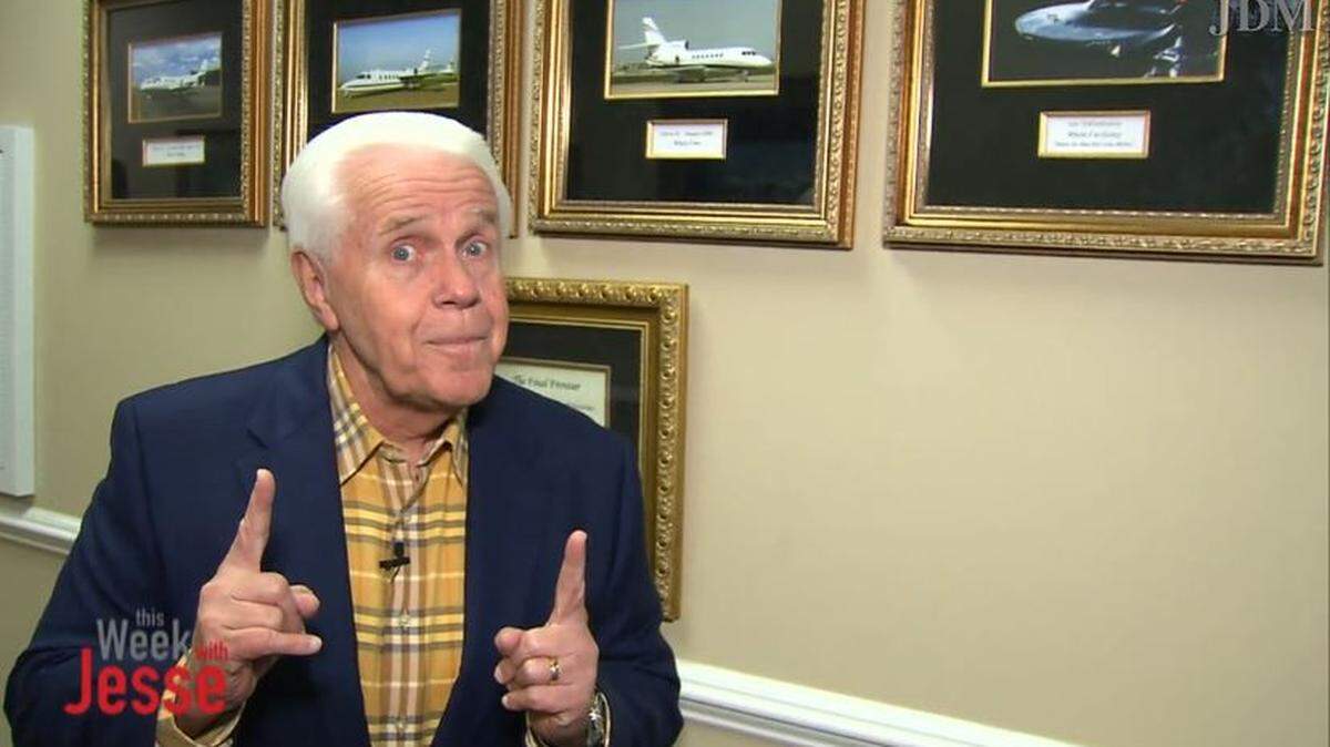 Jesse Duplantis argues that he needs a new private jet for his ministry, while standing in front of framed photos of his three private jets.