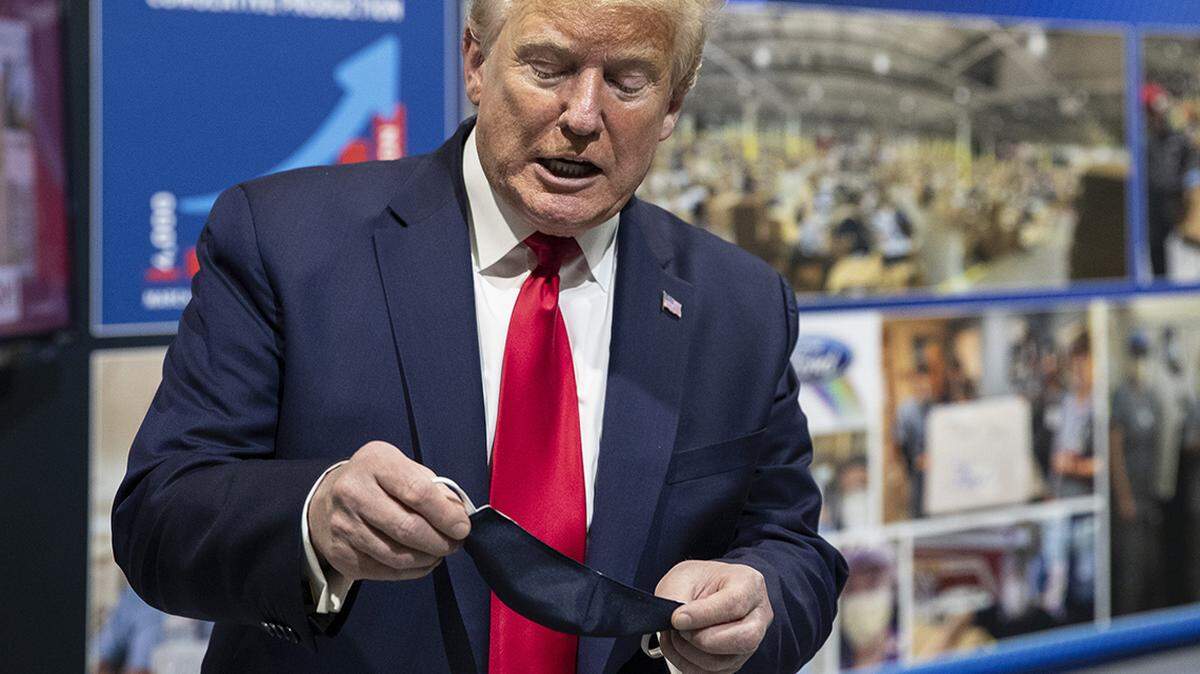 President Donald Trump holds his protective face mask as he speaks while touring Ford’s Rawsonville Components Plant that has been converted to making personal protection and medical equipment, Thursday, May 21, 2020, in Ypsilanti, Mich. (AP Photo/Alex Brandon)