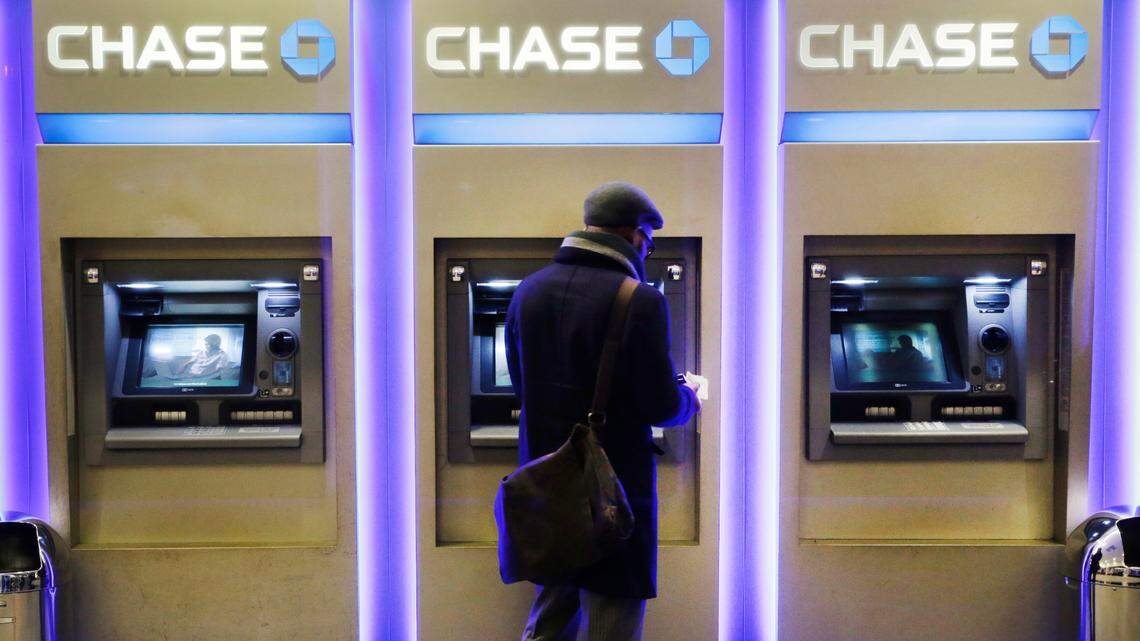 FILE - In this Wednesday, Jan. 14, 2015, file photo, a customer uses an ATM at a branch of Chase Bank, in New York.