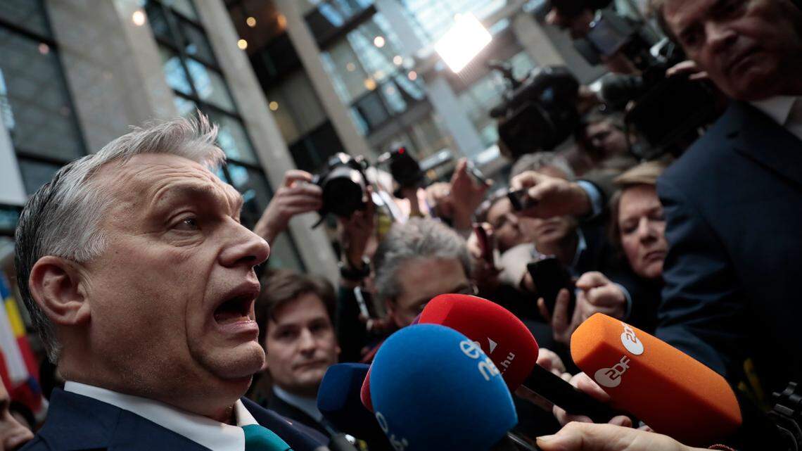 Hungarian Prime Minister Viktor Orban, left walks out into the main press room to brief journalists during an EU summit at the European Council building in Brussels, Friday, Feb. 21, 2020. In a second day of meetings EU leaders will continue to discuss the bloc’s budget to work out Europe’s spending plans for the next seven years. (AP Photo/Virginia Mayo)