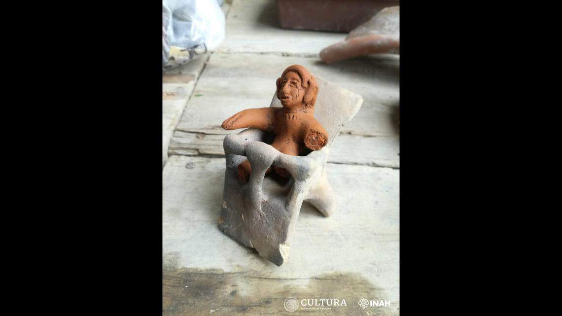 An Aztec figurine depicting an infant in a chair.