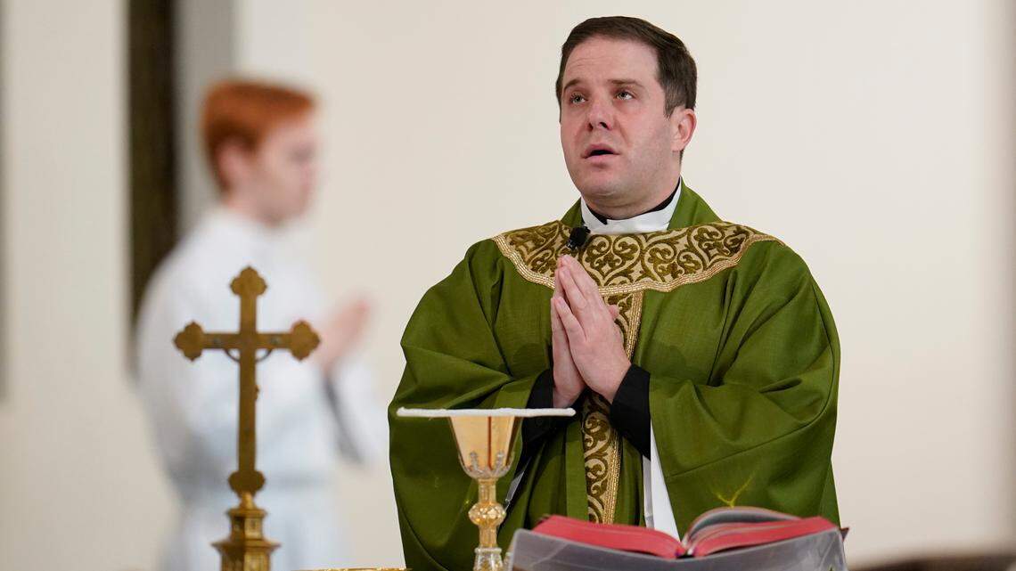 Father Matthew Hood celebrates mass at Our Lady of the Rosary church Friday, Feb. 18, 2022, in Detroit. In 2020, one word caught the ear of a young Detroit-area Catholic priest while he watched a video of his baptism from decades earlier. “Wait,” the Rev. Matthew Hood recalled thinking. “Something doesn’t seem right here.” Indeed, an error by a deacon had spoiled the sacrament — and, in domino-like fashion, meant he truly wasn’t a priest. (AP Photo/Paul Sancya)