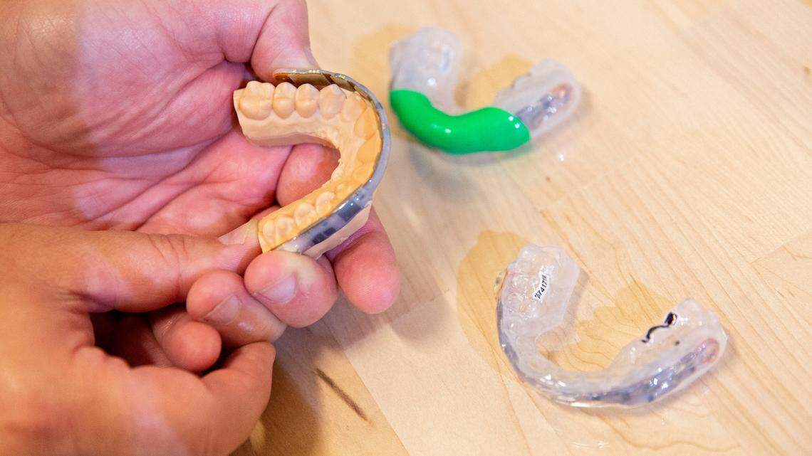 An engineer demonstrates on a player’s mouth mold where the sensor will fit once installed into the mouthguard in Charlottesville, Va., on Aug. 17, 2021. The NFL announced on Nov. 23, 2021, that it’s partnering with four universities to study head impacts on football players through the use of these high-tech mouthguards. (Ryan M. Kelly/AP Images for NFL)