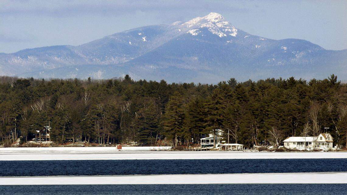 A snow capped Mount Chocorua looms over an unfrozen Lake Winnipesaukee in Laconia, N.H., in 2006. A hiker was rescued from the summit on Oct. 3, 2022. (AP Photo/Jim Cole)