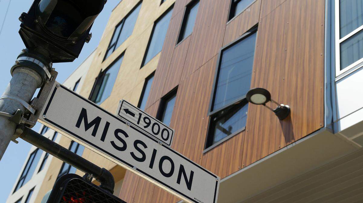 A street sign hangs outside a new apartment building on Mission Street, Tuesday, June 2, 2015, in San Francisco. Finding a place to live has become so expensive and emotional that city supervisors are considering a 45-day moratorium on luxury housing in the Mission District, which has long been one of the most diverse neighborhoods in the city. (AP Photo/Eric Risberg)