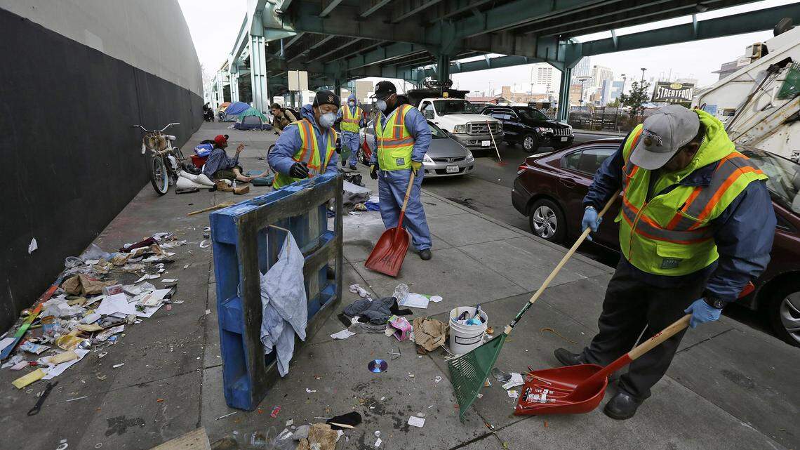 San Francisco city workers clear away debris that includes syringes from the remains of a tent city. The new ‘Snapcrap’ app lets iPhone users send pictures of poop, syringes and trash on the city’s dirty streets to 311 so it can be cleaned up.