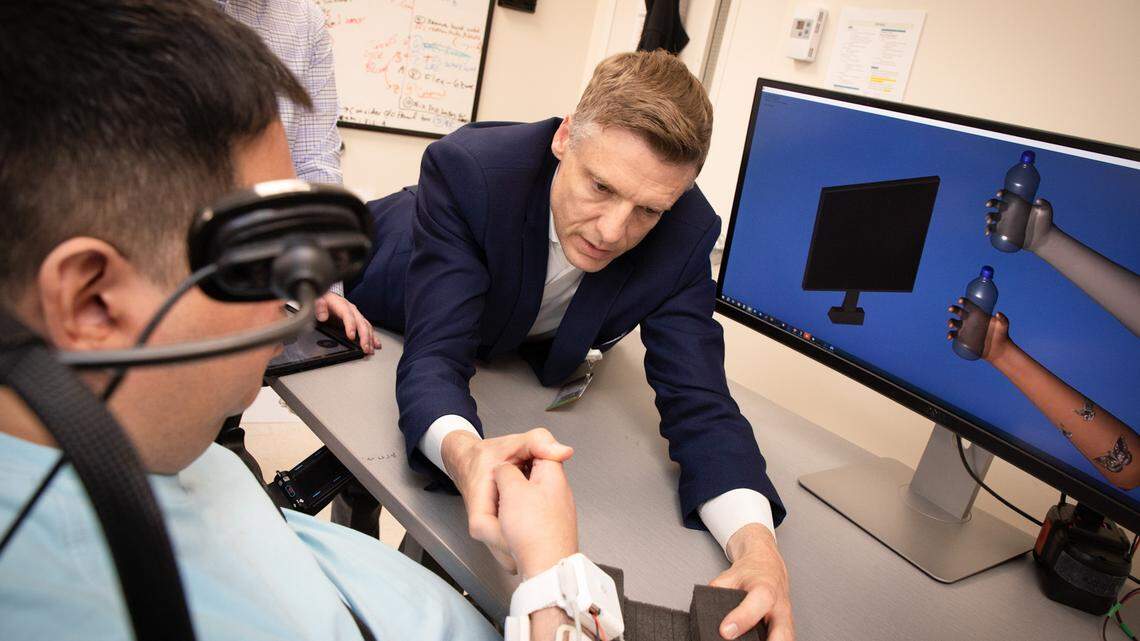 Chad Bouton, right, led a team of researchers, surgeons and engineers to develop a double neural bypass brain implant that helps restore movement and feeling for paralyzed patients.