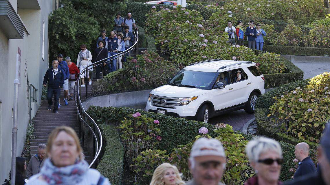 Tourists make their way down Lombard Street, also known as the “most crooked street” in San Francisco.