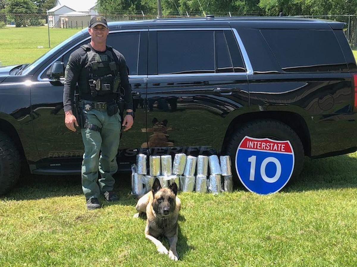 Fayette County Sheriff's Sgt. Randy Thumann and his K9 partner Lobos, with the 27 kg of meth the pair seixed Wwednesday during a traffic stop along Interstate 10 in Fayette County, Texas.