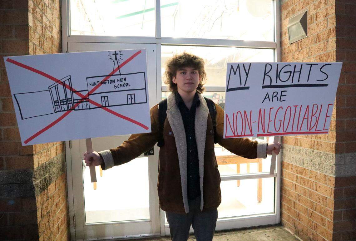 Huntington High School senior Max Nibert holds signs he plans to use during a walkout students are staging at Huntington High School in Huntington, W.Va. on Wednesday, Feb. 9, 2022. The protest follows an evangelistic Christian revival assembly last week that some students at Huntington High were mandated by teachers to attend – a violation of students’ civil rights, Nibert says. (AP Photo/Leah M. Willingham)