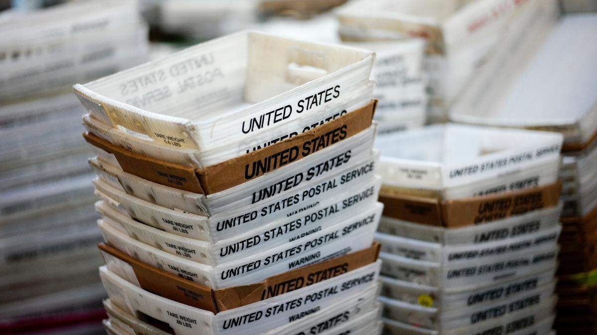 FILE- In this Dec. 14, 2017, file photo, boxes for sorted mail are stacked at the main post office in Omaha, Neb. (AP Photo/Nati Harnik, File)