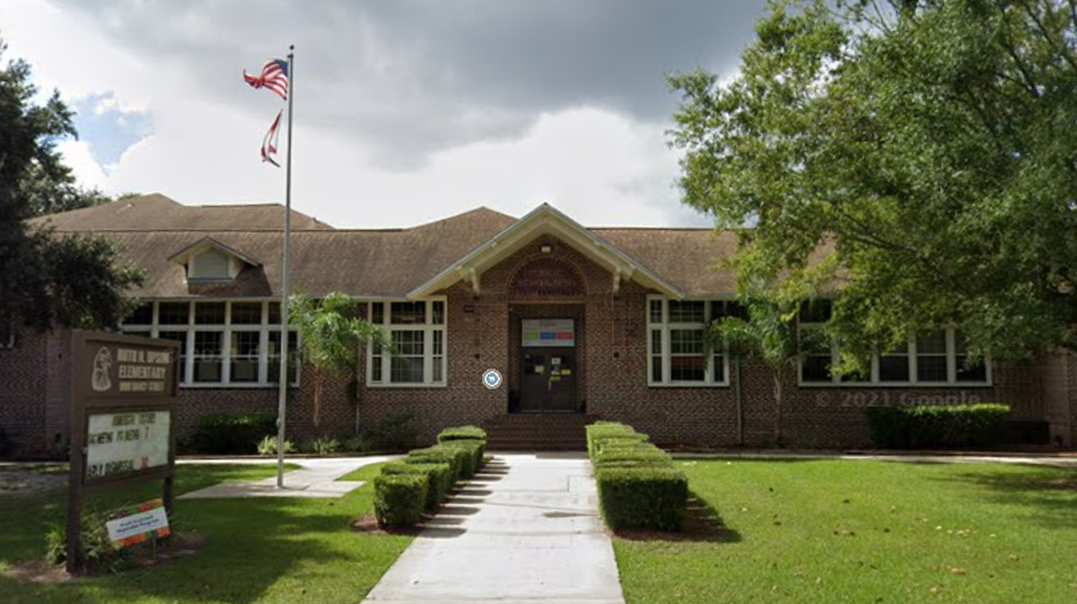 A man was shot by a school police officer after he tried to get into an elementary school while holding an ax, Florida police said.