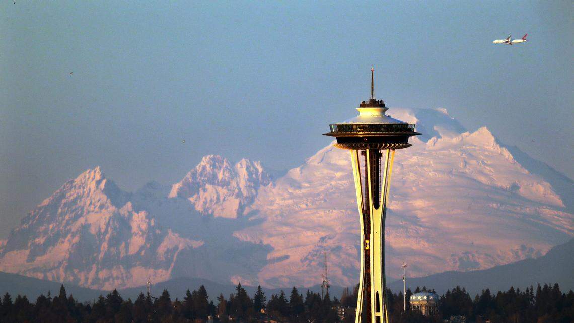 Mount Baker is seen some 85 miles distant behind the Space Needle under clear skies at sunset Thursday, Dec. 6, 2018, from Seattle.