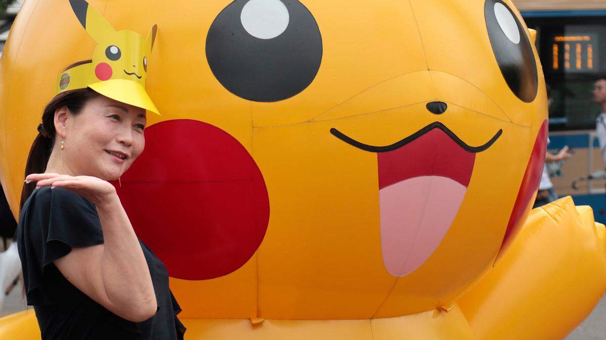 A woman poses with a balloon of Pokemon character Pikachu in 2017. On Jan. 7, 2022, an appellate court ruled that two former police officers in California were terminated fairly after they were accused of playing Pokemon Go instead of responding to a robbery. (AP Photo/Shizuo Kambayashi)