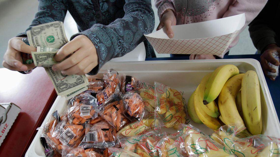 A student at Fairmeadow Elementary School pays for lunch consisting of fruits and vegetables during a school lunch program in Palo Alto, California.