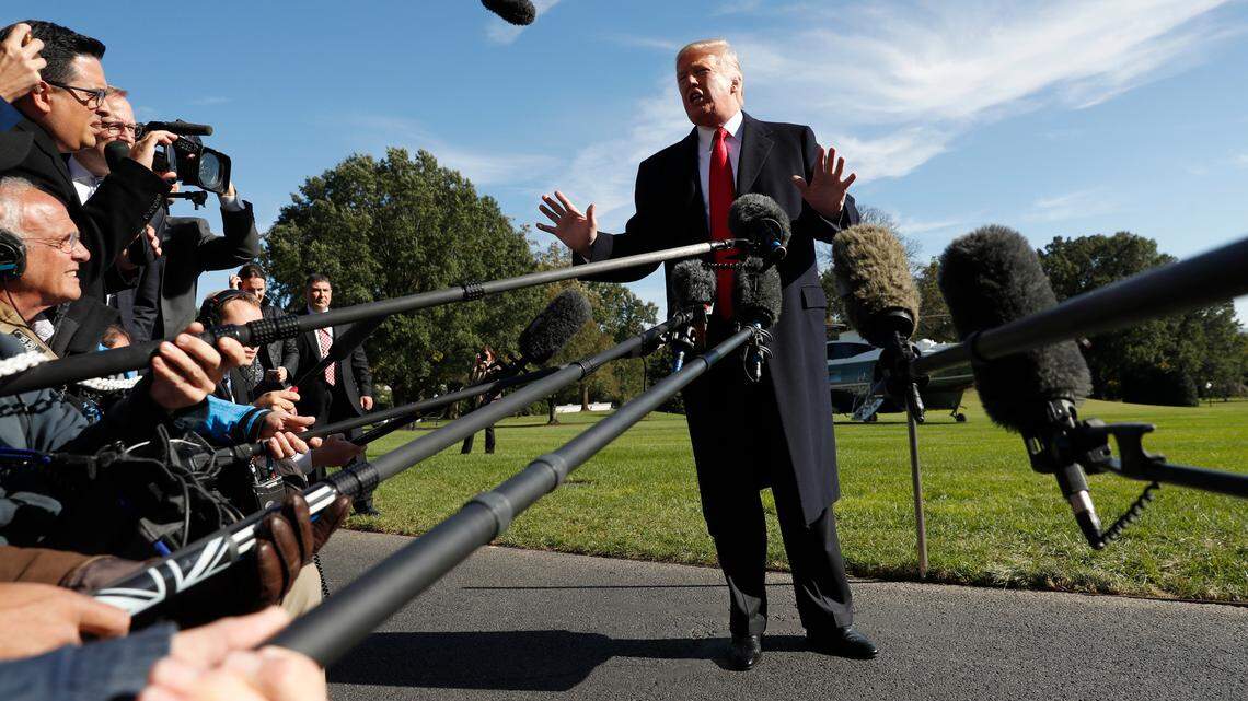 President Donald Trump stops to talk to members of the media before walking across the South Lawn of the White House in Washington on Monday.