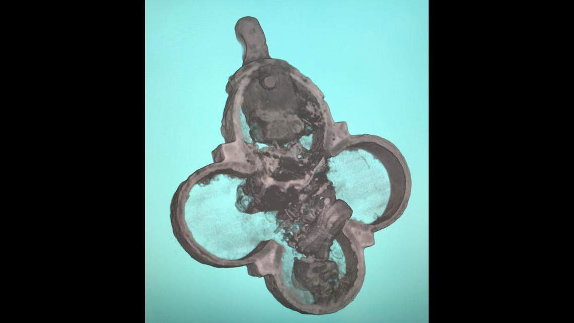 The interior of the pendant, which includes five packets, some containing bone fragments and tissue.