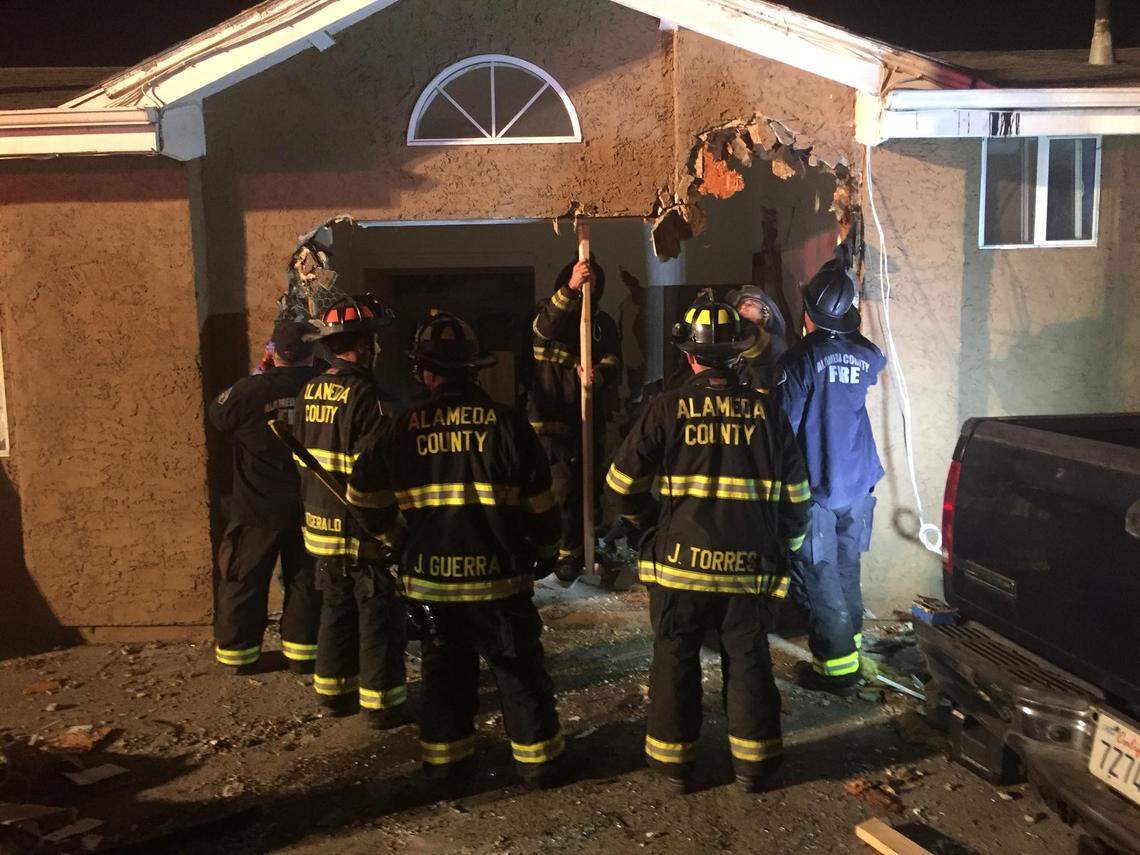 Firefighters begin working to shore up the building structurally after removing the car.