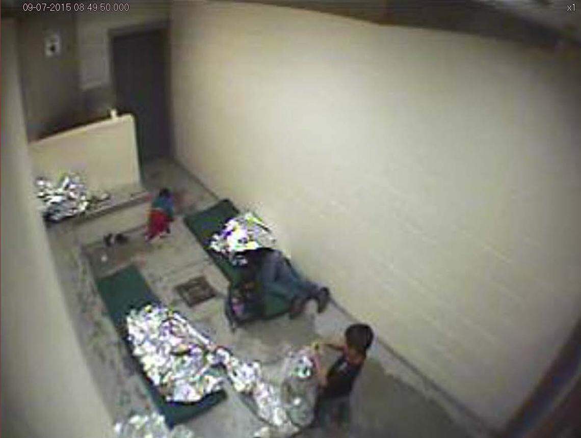 This September, 2015, file image made from U.S. Border Patrol surveillance video shows a child crawling on the concrete floor near the bathroom area of a holding cell, and a woman and children wrapped in Mylar sheets at a U.S. Customs and Border Protection station in Douglas, Ariz.