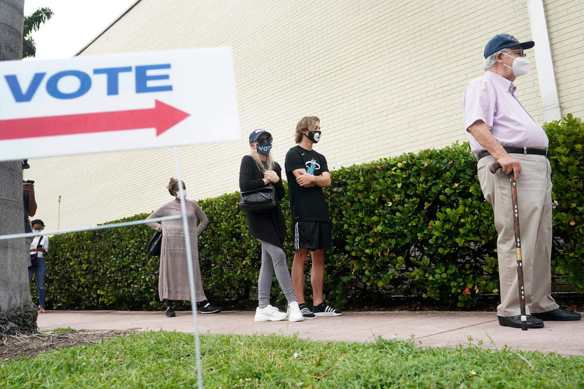 People wait in line to vote outside of an early voting site, Tuesday, Oct. 20, 2020, in Miami Beach, Fla. Florida began in-person early voting in much of the state Monday. With its 29 electoral votes, Florida is crucial to both candidates in order to win the White House. (AP Photo/Wilfredo Lee)