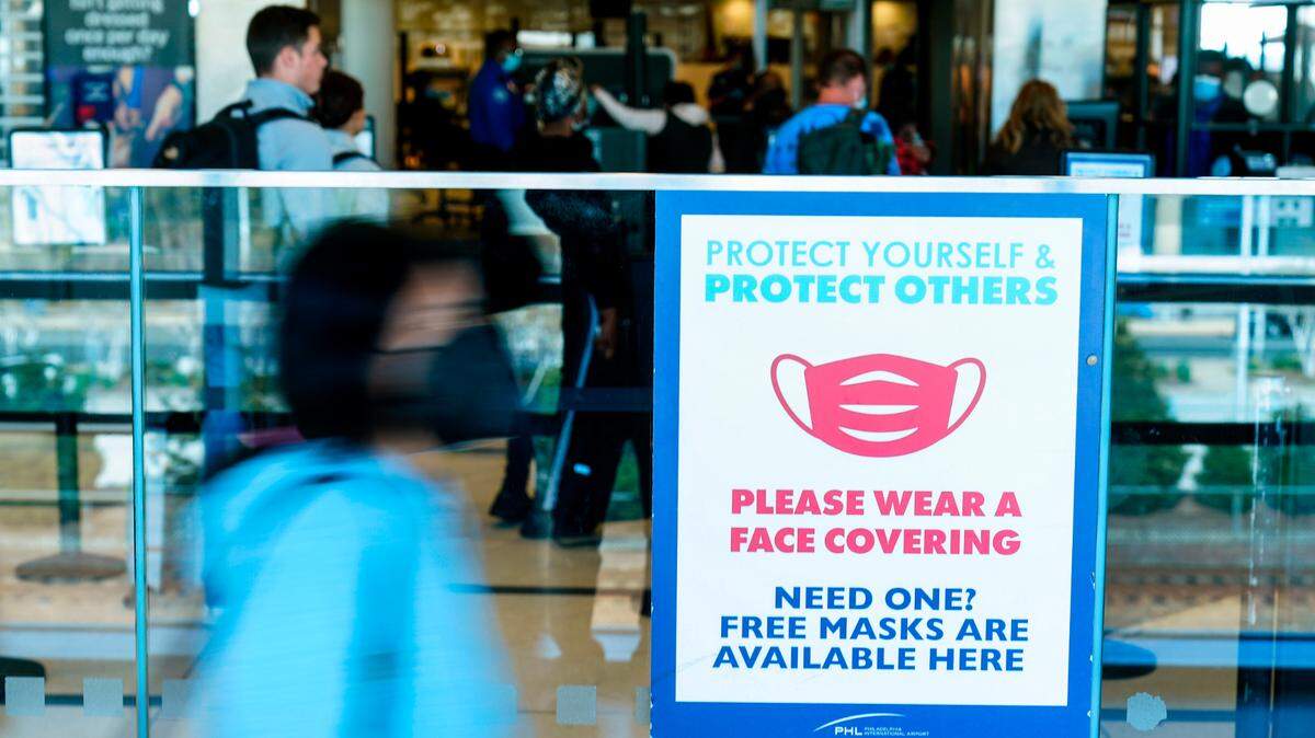 A sign urges travelers to wear masks as a precaution against the spread of the coronavirus at the Philadelphia International Airport on Tuesday, April 19, 2022. A federal judge’s decision to strike down a mask mandate was met with cheers on some airplanes but also concern about whether it’s really time to end one of the most visible vestiges of the COVID-19 pandemic. (AP Photo/Matt Rourke)