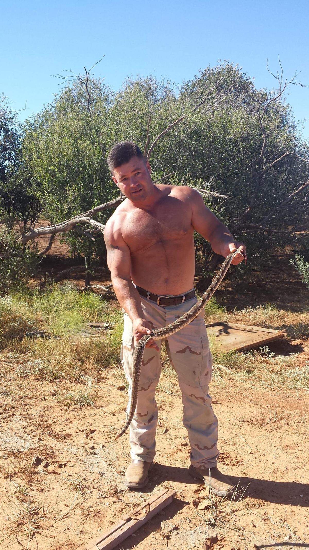 “Big John” Washburn, of Crandall, Texas, poses with the rattlesnake that would later appear to come back to life on the grill.