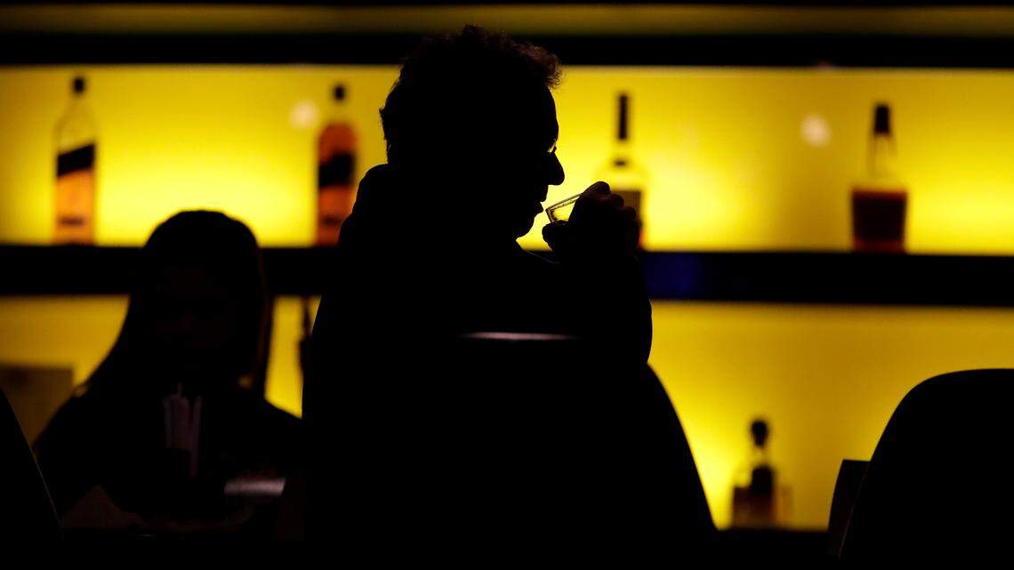 FILE - In this Nov. 30, 2017 photo, a patron sips his drink while having a meal at a bar in New Jersey. More government data points to alcohol’s increasing role in U.S deaths, including a new report that found that the alcohol-induced death rate rose nearly 30% during the first year of the COVID-19 pandemic. (AP Photo/Julio Cortez, File)